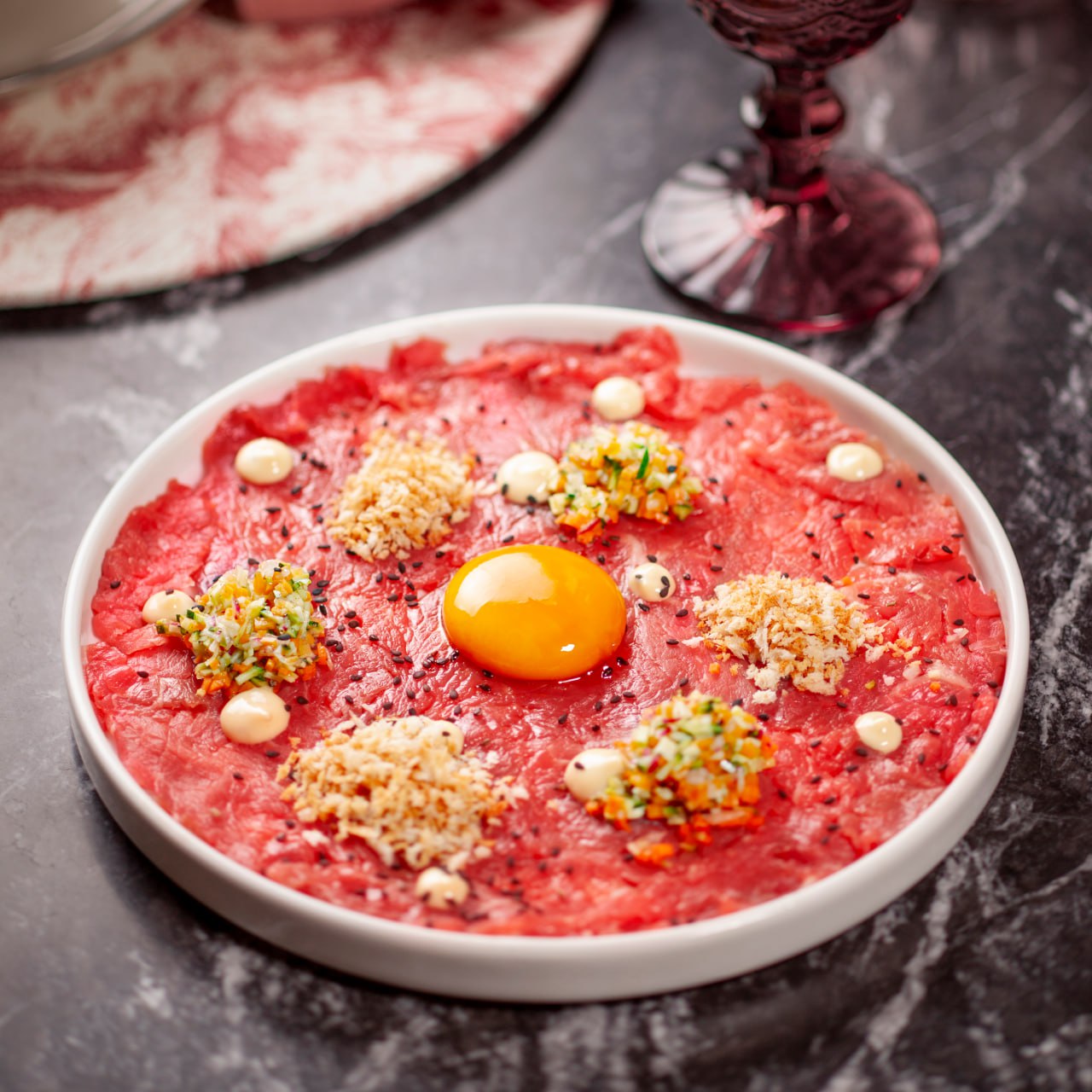 Carpaccio con tuorlo e piccoli dettagli di condimento